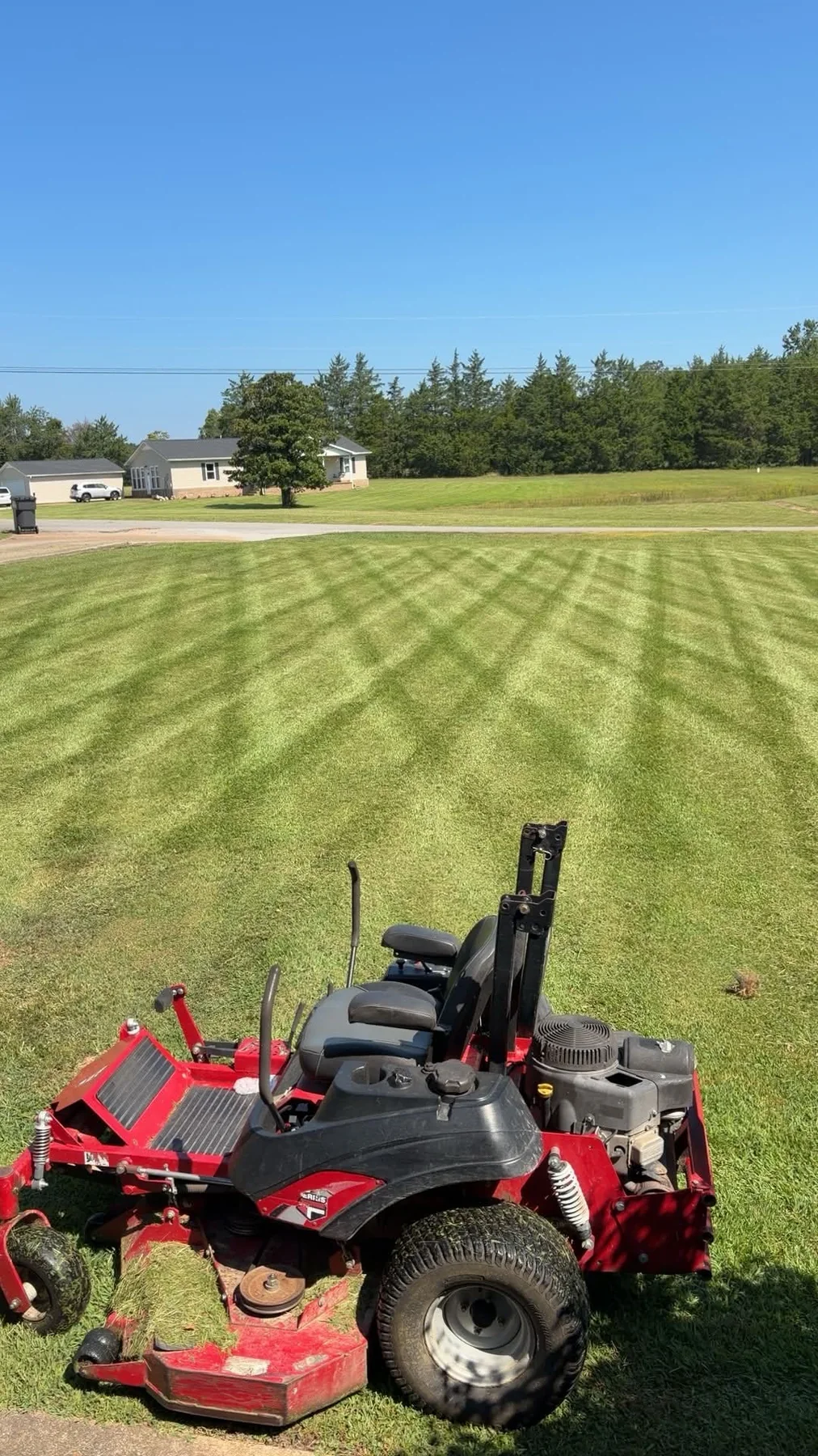 Zero-turn mower on a freshly cut striped lawn