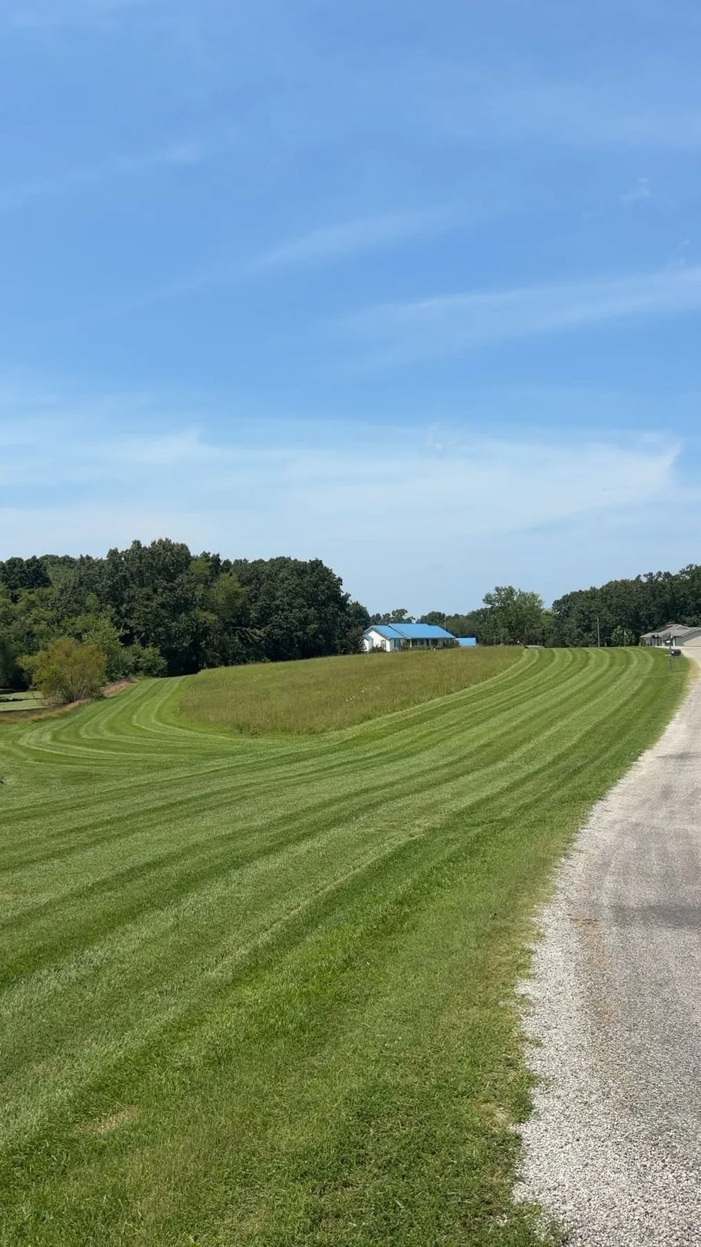 Long cut lawn beside a gravel drive