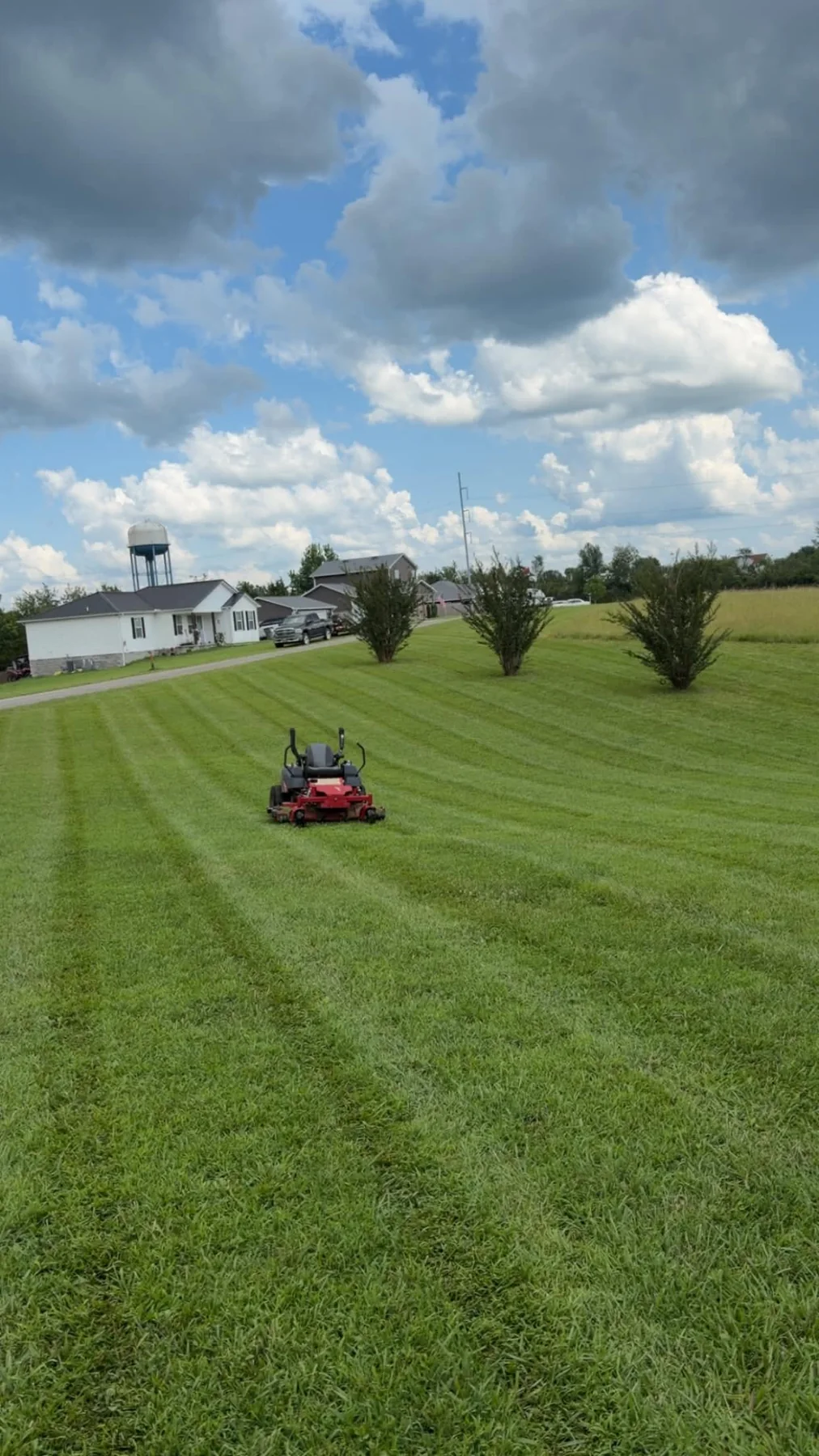 Mower working across a large striped property